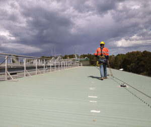 Person using a fall restraint system on rooftop.